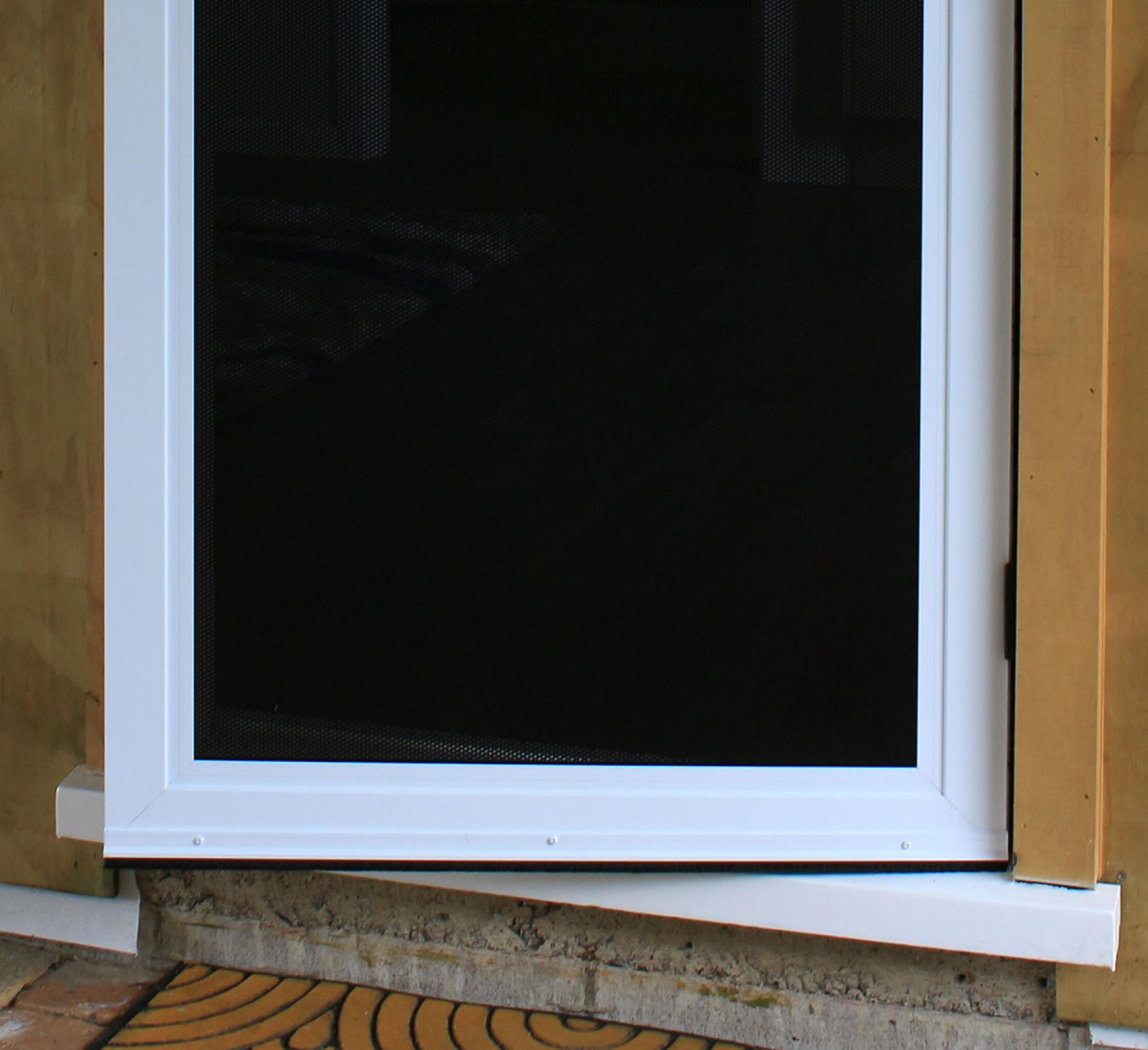 Image of man installing screen on door